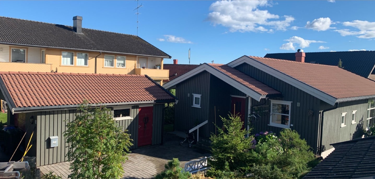 Nærbilde som viser den skarpe kontrasten mellom rengjort, rød takstein og ubehandlet overflate preget av mose og skitt.